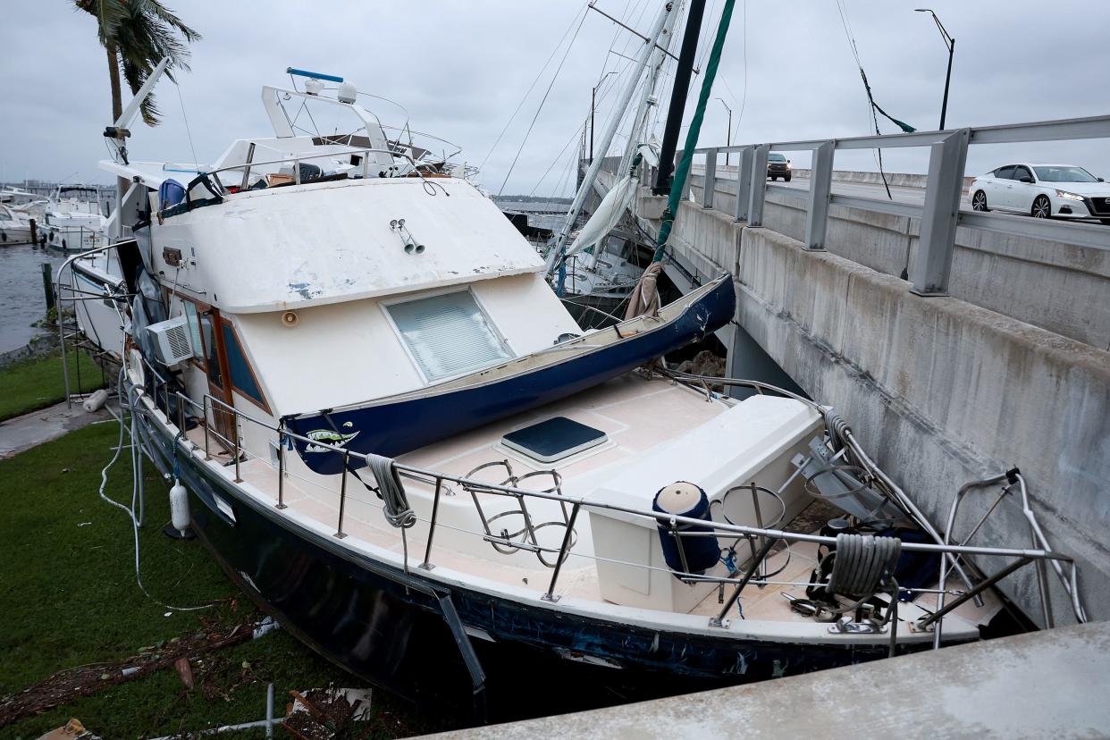 Boats are pushed up on a causeway after Hurricane Ian passed through the area on Sept. 29, 2022, in Fort Myers, Fla.