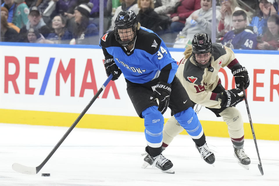 Toronto's Hannah Miller takes the puck past Montreal's Maureen Murphy during the first period of a PWHL hockey game Friday, Feb. 16, 2024, in Toronto. (Chris Young/The Canadian Press via AP)