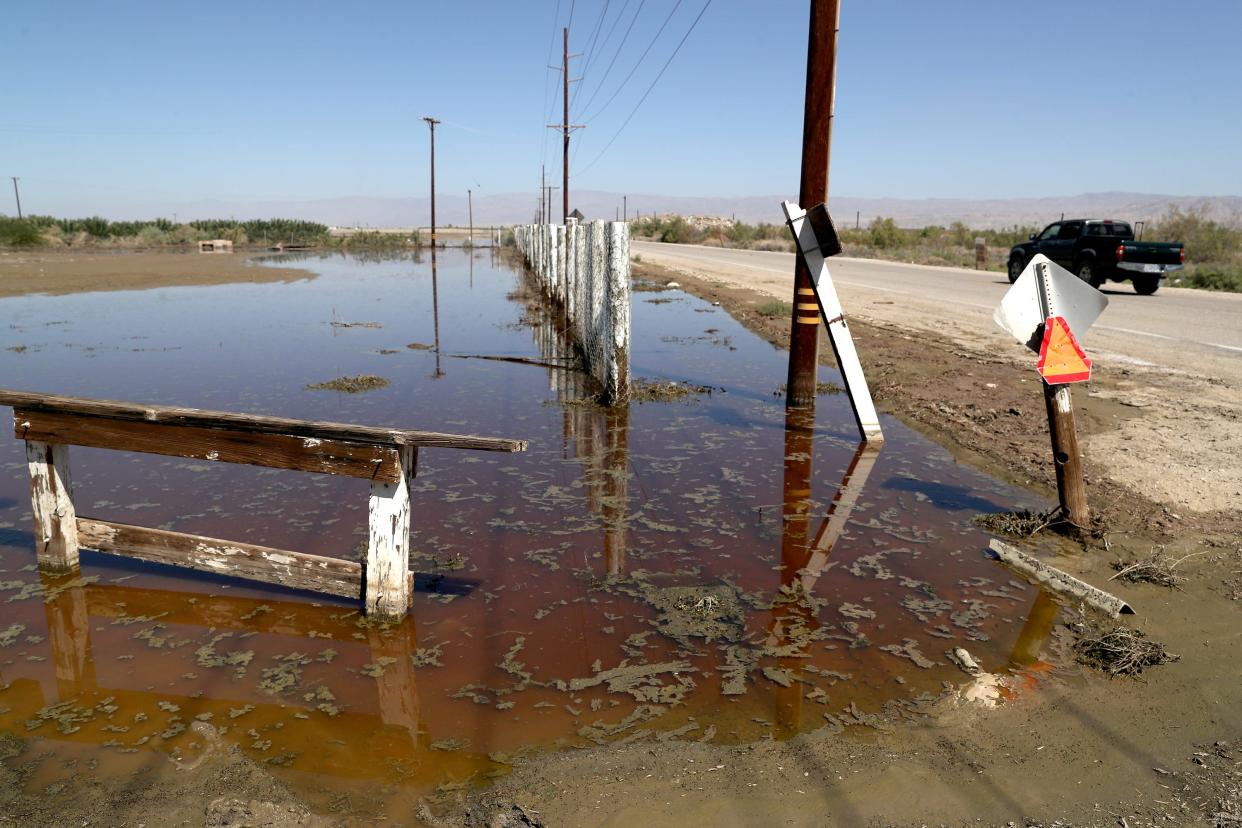 Standing water is visible Wednesday along Pierce Street in Thermal, near the Vargas Mobile Home Park. County officials are doing testing to see whether floodwaters in the area contain toxic material from a dump site breach.