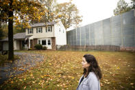 In this Tuesday, Oct. 22, 2019 photo, Carrie Gross walks past a construction barrier shielding the Mariner East pipeline near a home during an interview with The Associated Press in Exton, Pa. The pipeline route traverses those suburbs, close to schools, ballfields and senior care facilities. "It's absolutely traumatic and I don't say that to exaggerate or cry wolf," said Gross, referring to the project that runs through backyards in her middle-class Philadelphia suburb of Uwchlan Township. "It's devastated my neighborhood." (AP Photo/Matt Rourke)