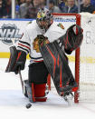 Chicago Blackhawks goaltender Corey Crawford (50) deflects the puck during the second period of an NHL hockey game against the St. Louis Blues Tuesday Feb. 25, 2020, in St. Louis. (AP Photo/Scott Kane)