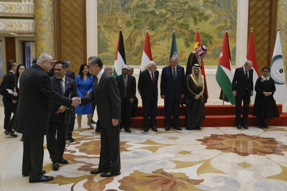 Chinese Foreign Minister Wang Yi, foreground right, shakes hands with delegates as he welcomes the five Arab and Islamic counterparts, far from left, Indonesian Foreign Minister Retno Marsudi, Jordanian Deputy Prime Minister and Foreign Minister Ayman Safadi, Saudi Arabia's Foreign Minister Faisal bin Farhan Al Saud, Egyptian Foreign Minister Sameh Shoukry, Palestinian Foreign Minister Riyad al-Maliki, and Secretary-General of the Organization of Islamic Cooperation (OIC) Hissein Brahim Taha prior to their meeting at the Diaoyutai state guesthouse in Beijing, Monday, Nov. 20, 2023. China's foreign minister welcomed five Arab and Islamic counterparts to Beijing on Monday, saying his country would work with "our brothers and sisters" in the Arab and Islamic world to try to end the fighting in Gaza as soon as possible. (AP Photo/Andy Wong)