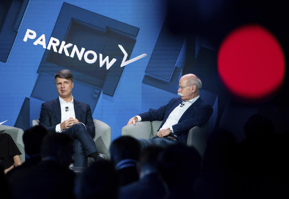 BMW CEO Harald Krueger, left, and Mercedes-Benz CEO Dieter Zetsche of Daimler, right, talk to the media at a press conference in Berlin, Germany, Friday, Feb. 22, 2019. Automakers Daimler and BMW are formally launching their joint venture in services that make it possible to use their cars without necessarily owning one. (Bernd von Jutrczenka/dpa via AP)