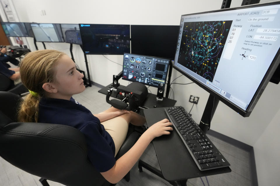 Julia Nance, 14, works on a flight simulator in a class taught by her father, James Nance, Monday, April 15, 2024, at A.D. Henderson School in Boca Raton, Fla. While many teachers nationally complain their districts dictate textbooks and course work, the South Florida school's administrators allow their staff high levels of classroom creativity...and it works. (AP Photo/Wilfredo Lee)