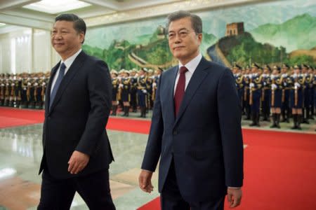 South Korean President Moon Jae-In and Chinese President Xi Jinping review the Chinese honour guard during a welcome ceremony at the Great Hall of the People in Beijing, China December 14, 2017. REUTERS/Nicolas Asfouri/Pool