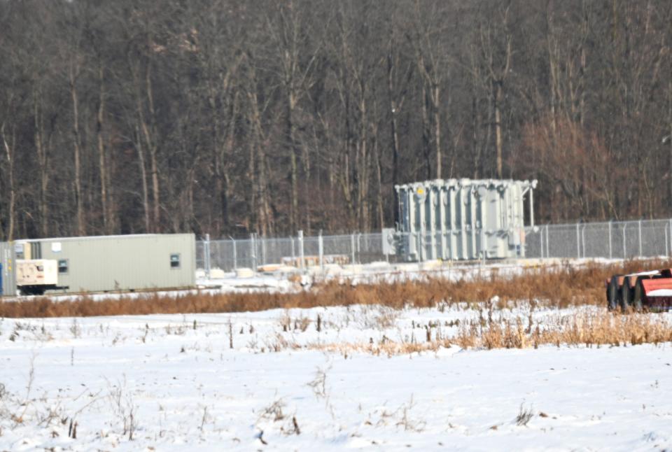 The giant 250 ton power transformer sits in a field off Hayter Road. The unit looks small until compared to nearby construction trailers.
