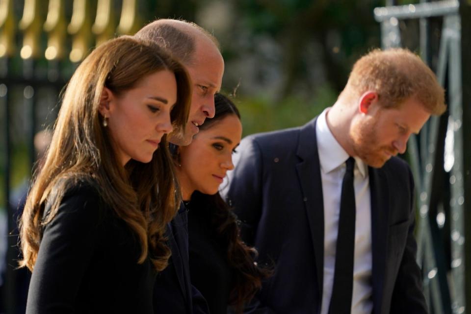 Britain’s Prince William and Kate, Princess of Wales, left, and Britain’s Prince Harry and Meghan, Duchess of Sussex walk to greet the crowds after viewing the floral tributes for the late Queen Elizabeth II outside Windsor Castle (AP)