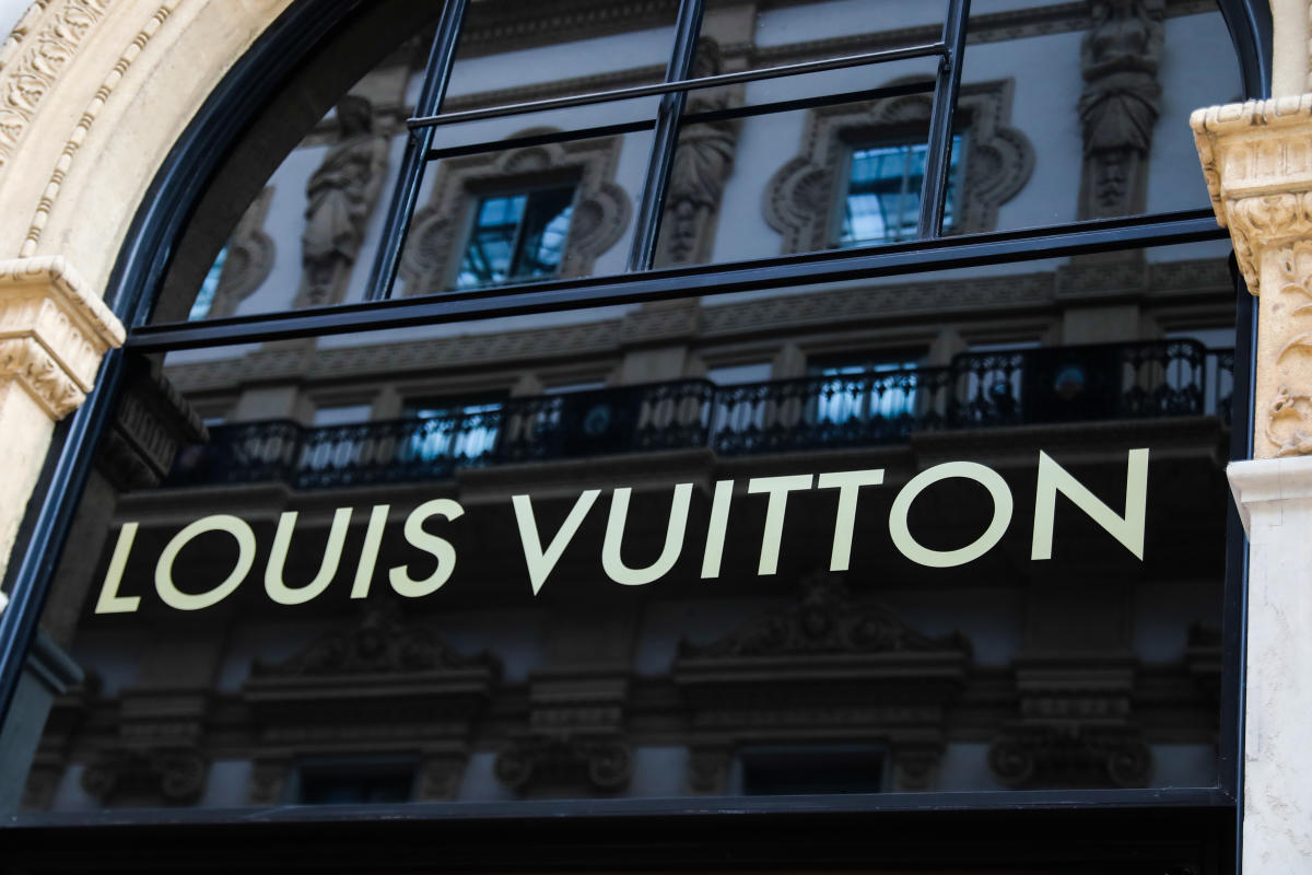People sit outside a Louis Vuitton store, operated by LVMH Moet News  Photo - Getty Images
