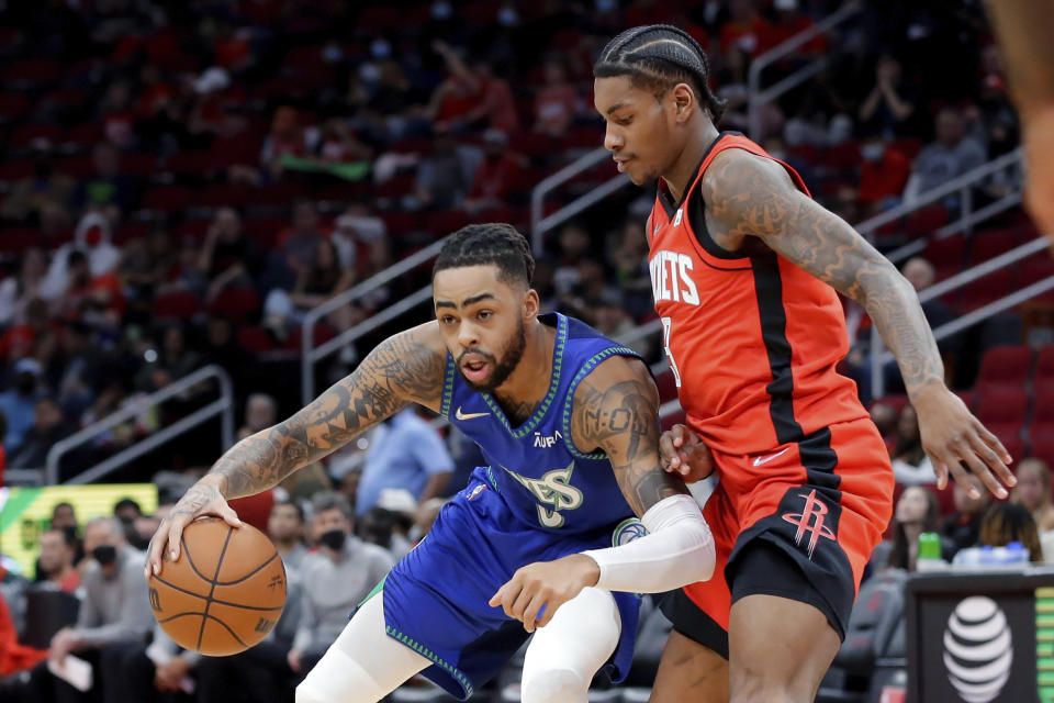 Minnesota Timberwolves guard D'Angelo Russell, left, drives around Houston Rockets guard Kevin Porter Jr., right, during the first half of an NBA basketball game Sunday, Jan. 9, 2022, in Houston. (AP Photo/Michael Wyke)