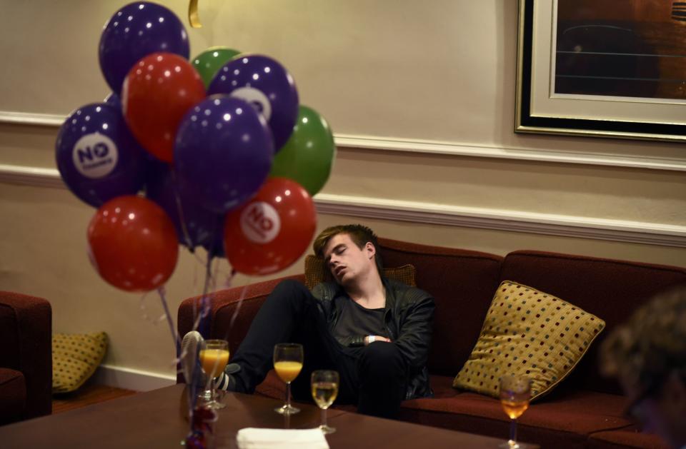 A supporter from the "No" Campaign sleeps as he waits for the announcement of results, at the Better Together Campaign headquarters in Glasgow, Scotland