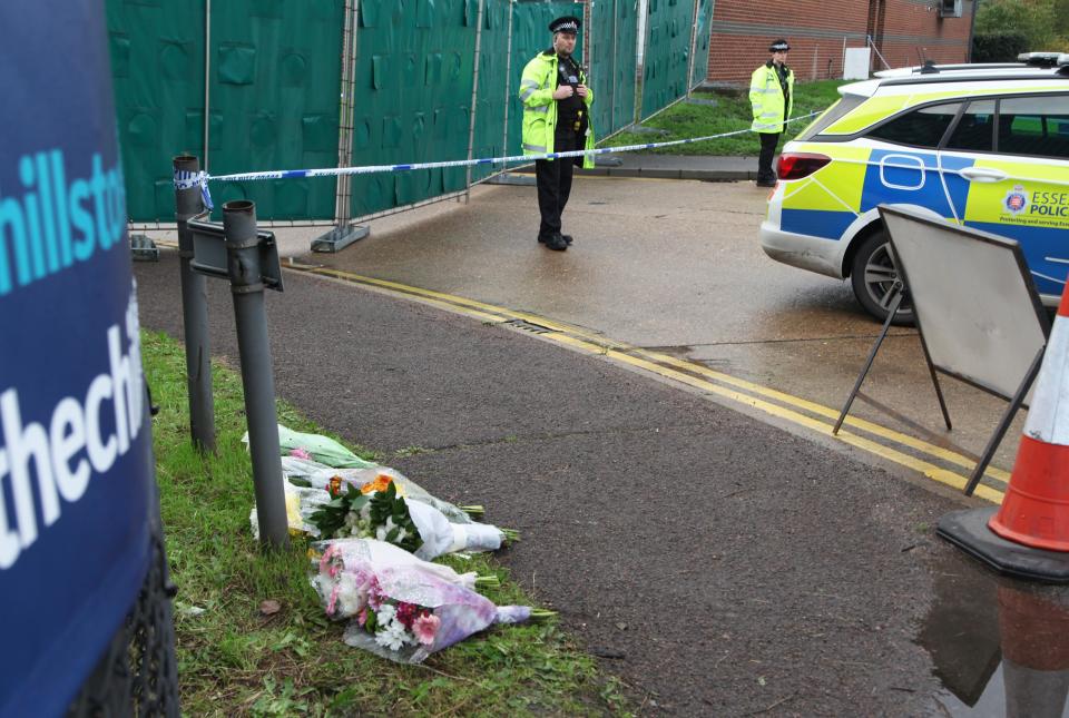 THURROCK, ENGLAND - OCTOBER 24: Flowers lay next to a police line cordon at the scene where 39 bodies discovered in the back of a lorry on October 24, 2019 in Thurrock, England. The lorry was discovered early Wednesday morning in Waterglade Industrial Park on Eastern Avenue in the town of Grays. (Photo by Zhang Ping/China News Service/VCG via Getty Images)