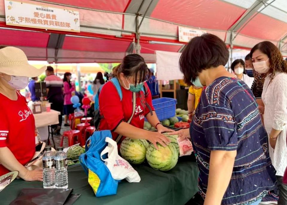 龍井農會提供龍井身心障礙者協會及宇熙慢飛寶貝戰鼓隊各一千公斤西瓜進行義賣，所得將全部捐贈弱勢團體。（記者陳金龍攝）