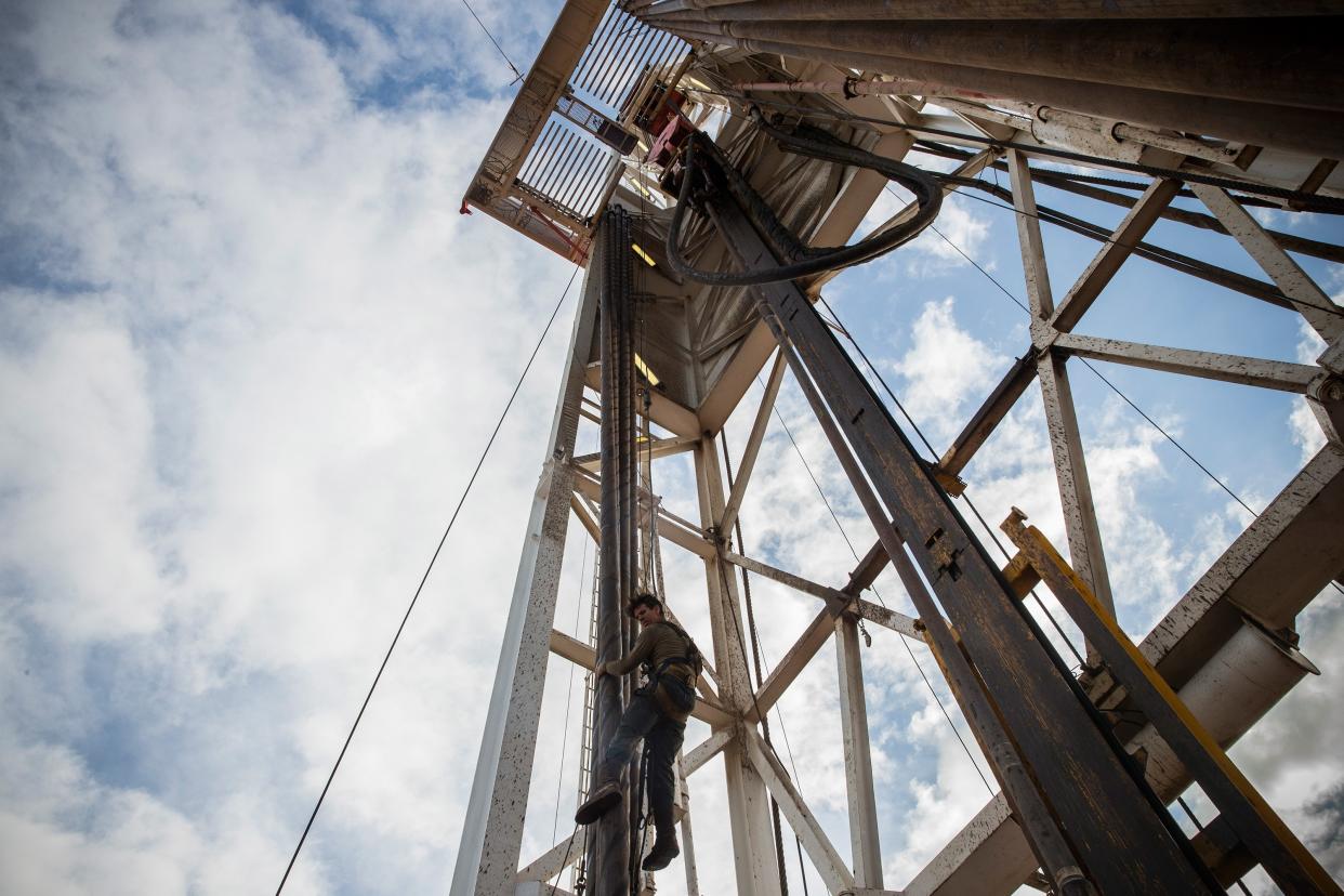 Jeff Allyn, a derrick hand with Raven Drilling, is lowered down from the top of a derrick while drilling for oil in the Bakken shale formation on July 23, 2013 outside Watford City, North Dakota. (Photo by Andrew Burton/Getty Images)