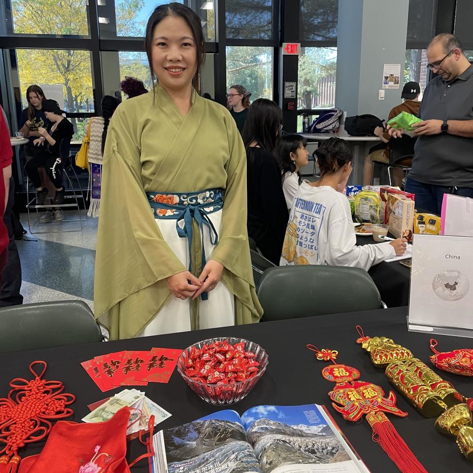 MVCC career counselor Yue Riesbeck stands at a table of Chinese New Year decorations.