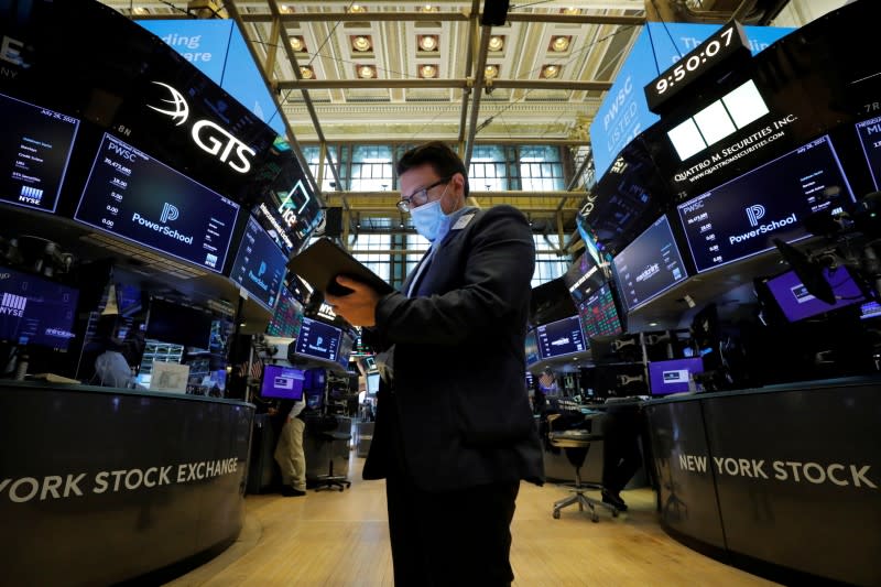 FILE PHOTO: A trader works on the floor of the New York Stock Exchange (NYSE) in New York City, New York