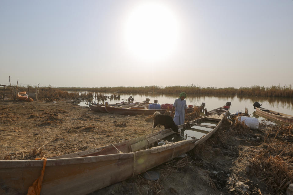 Fisherman fill their boats with collected fresh water as the sun sets in the marshes of Chibayish which has suffered fresh water shortages because of declining river levels and drought, in Dhi Qar province, Iraq, Friday Sept. 2, 2022. (AP Photo/Anmar Khalil)