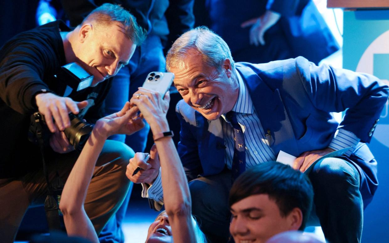 Nigel Farage takes a selfie with a supporter as he attends a campaign event in Clacton-on-Sea