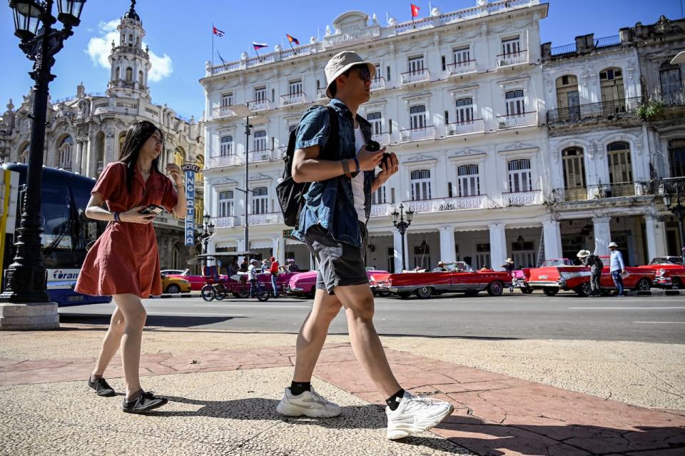 Tourists walk along a street in Havana on December 20, 2023. Cuba's economy will shrink by up to 2 per cent this year, Finance Minister Alejandro Gil estimated on Wednesday, after acknowledging that the country will not be able to achieve the projected economic growth of 3 per cent by 2023.