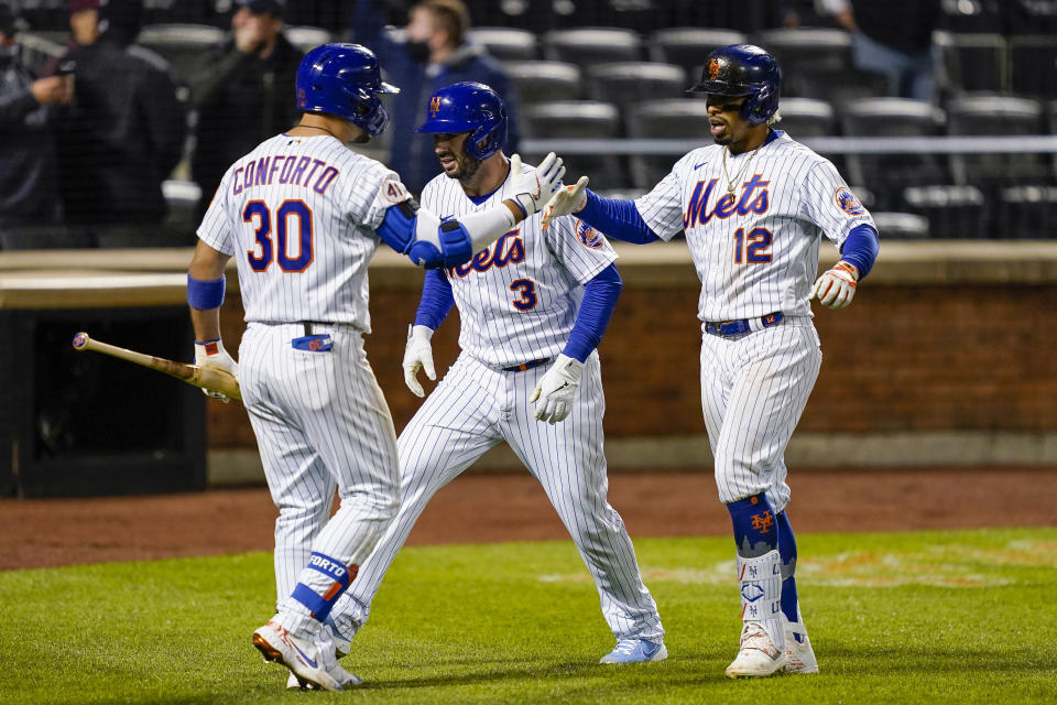 New York Mets' Francisco Lindor (12) celebrates with Tomas Nido (3) and Michael Conforto (30) after hitting a two-run home run off Arizona Diamondbacks pitcher Caleb Smith during the seventh inning of a baseball game Friday, May 7, 2021, in New York. (AP Photo/John Minchillo)