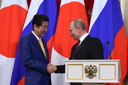 Russian President Vladimir Putin (R) and Japanese Prime Minister Shinzo Abe shake hands while making a joint statement following their meeting at the Kremlin in Moscow, Russia January 22, 2019. Alexander Nemenov/Pool via REUTERS
