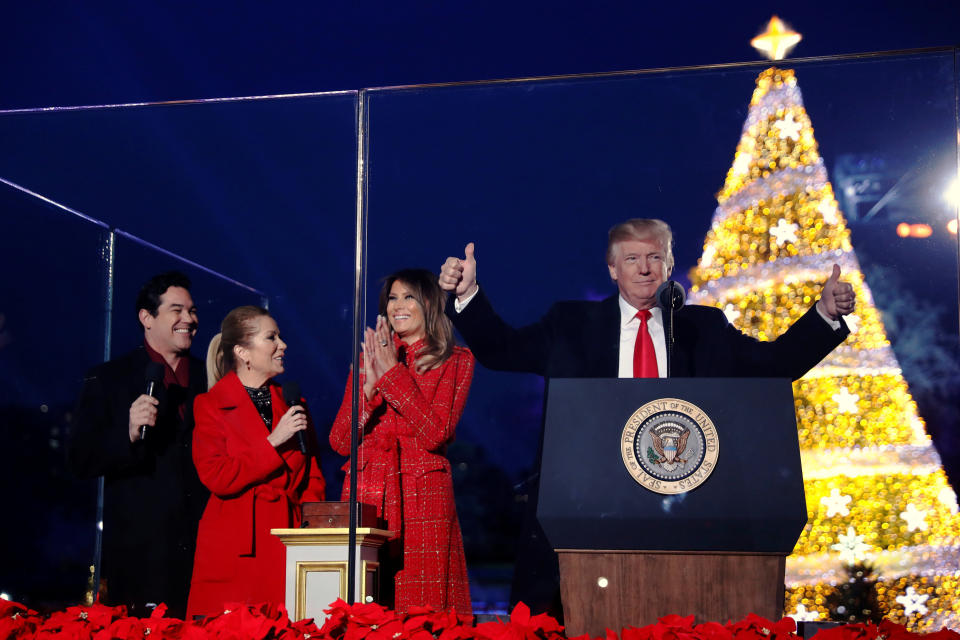 U.S. first lady Melania Trump, with U.S. President Donald Trump and hosts Dean Cain (L) and Kathie Lee Gifford (2nd L), reacts after she pressed the button to light the tree during the National Christmas Tree lighting ceremony near the White House in Washington, U.S. November 30, 2017.  REUTERS/Jonathan Ernst