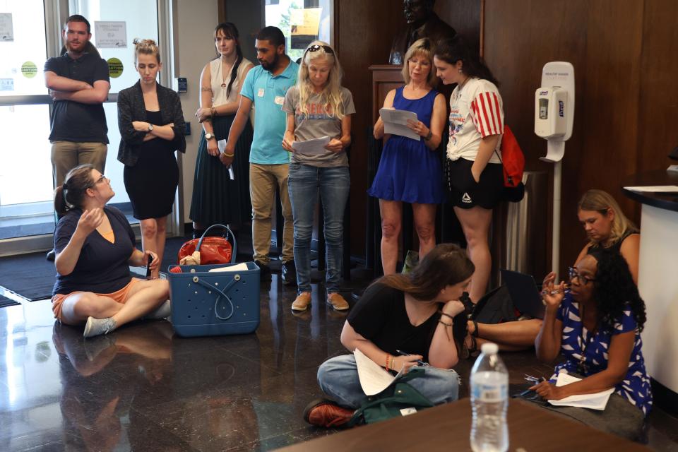 People sit in the lobby of the Oklahoma State Department of Education building during an Oklahoma State Board of Education meeting, Thursday, Aug. 24, 2023.