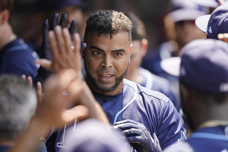 Tampa Bay Rays' Nelson Cruz is congratulated by teammates after hitting a solo home run in the sixth inning of a baseball game against the Cleveland Indians, Sunday, July 25, 2021, in Cleveland. (AP Photo/Tony Dejak)