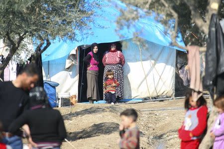 People stand outside tents housing internally displaced people in Salqin town, in Idlib province, Syria February 9, 2016. REUTERS/Ammar Abdullah