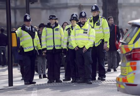 Police officers wait to cross the road outside the Houses of Parliament following a recent attack in Westminster, London, Britain March 24, 2017. REUTERS/Darren Staples