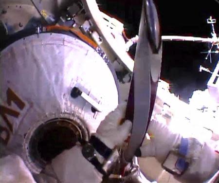 Russian astronaut Oleg Kotov holds an Olympic torch as he prepares to take it on a spacewalk outside the International Space Station