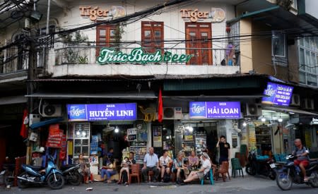 Tourists drink beer at a restaurant in the Old Quarters in Hanoi