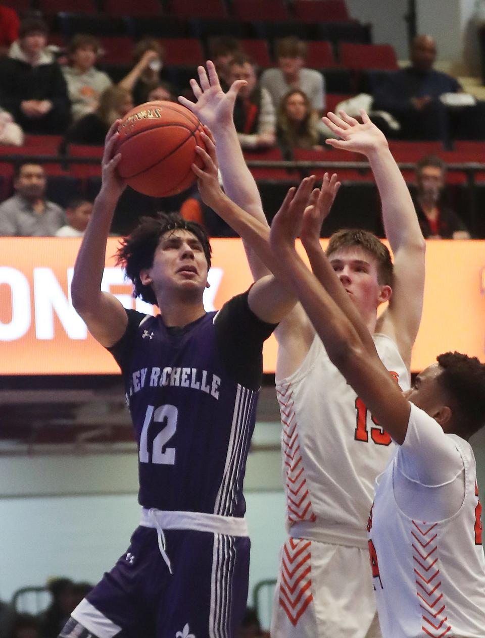 New Rochelle's Kasim Mirza (12) goes up for a shot against Mamaroneck during the Section 1 Class AAA semifinal at the Westchester County Center in White Plains Feb. 28, 2024. New Rochelle won the game in overtime 52-50.