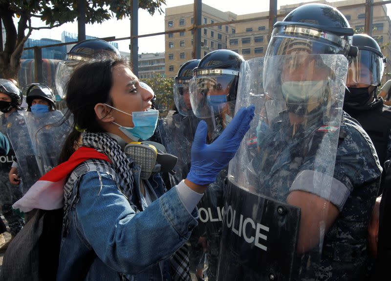 A demonstrator gestures to a Lebanese police officers during a protest against growing economic hardship in Beirut