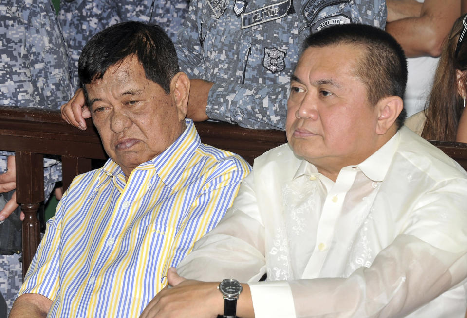 Andal Ampatuan Sr. , left, a powerful Filipino clan leader who is a suspect in the 2009 massacre of 57 people, sits beside his lawyer Sigfrid Fortun during his arraignment on electoral sabotage at the Pasay city regional trial court, south of Manila, Philippines on Monday March 26, 2012. Andal Sr. has been on trial for murder and on Monday pleaded not guilty to charges of rigging elections to favor former President Gloria Macapagal Arroyo's allies. (AP Photo/Noel Celis, Pool)