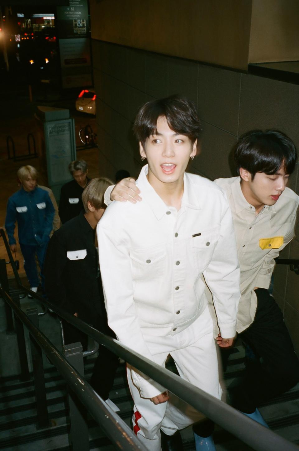 Jungkook, Jin, and the rest of the band, climbing the stairs up to Dave and Buster’s.