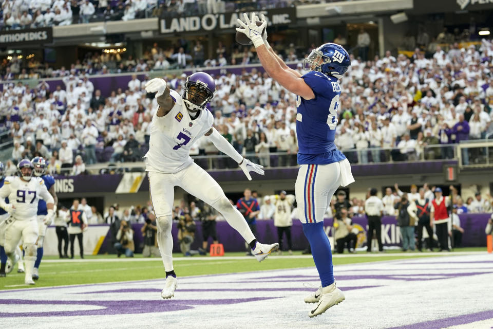 New York Giants tight end Daniel Bellinger (82) catches a two-point conversion pass ahead of Minnesota Vikings cornerback Patrick Peterson (7) during the second half of an NFL football game, Saturday, Dec. 24, 2022, in Minneapolis. The Vikings won 27-24. (AP Photo/Abbie Parr)