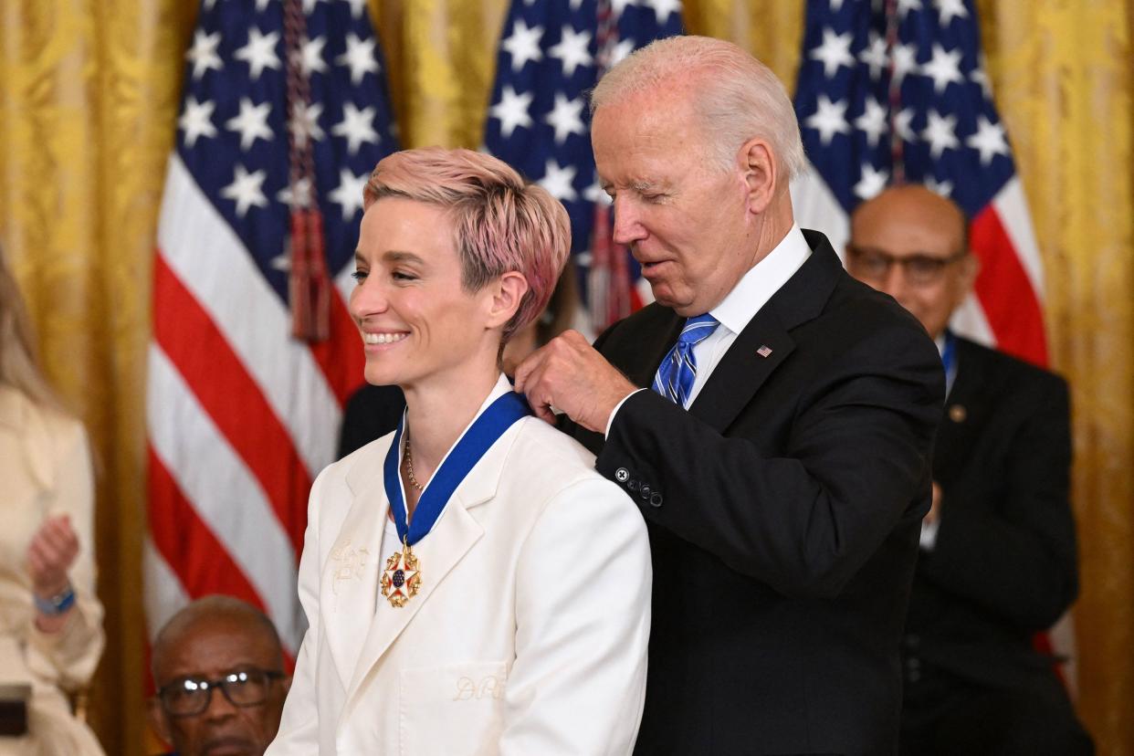 U.S. President Joe Biden presents soccer player Megan Rapinoe with the Presidential Medal of Freedom, the nation's highest civilian honor, during a ceremony honoring 17 recipients in the East Room of the White House in Washington, DC on July 7, 2022.
