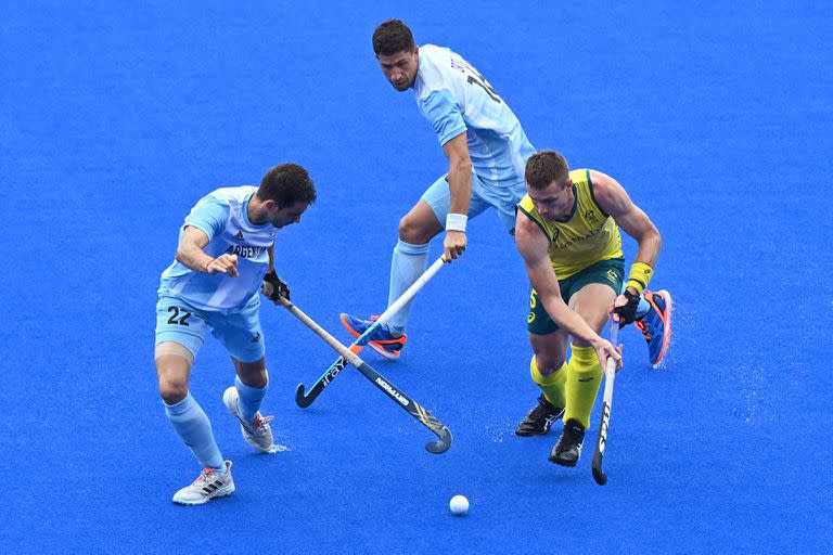 Los argentinos Matias Alejandro Rey (izq.) E Ignacio Horacio Ortiz marcan al australiano Tom Joseph Wickham durante un partido del grupo A de la competencia de hockey sobre césped