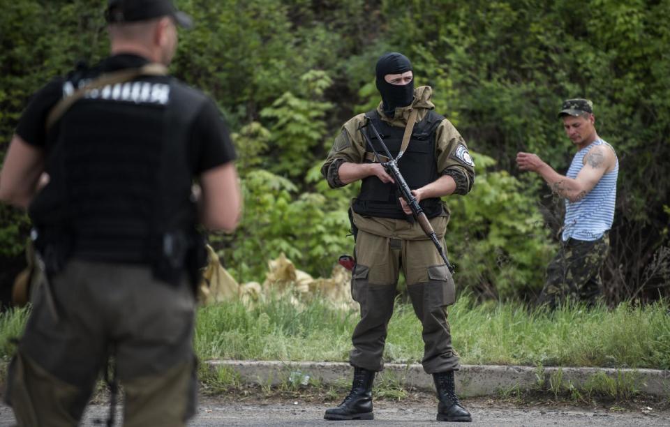 A Ukrainian police and paratroopers guard as they and other comrades block a road outside the town of Slovyansk, eastern Ukraine, Sunday, May 4, 2014. Ukrainian authorities are currently seeking to form a security cordon around the town. They have repeatedly claimed victories in capturing checkpoints surrounding the city, although such boasts have often proven overstated. (AP Photo/Evgeniy Maloletka)