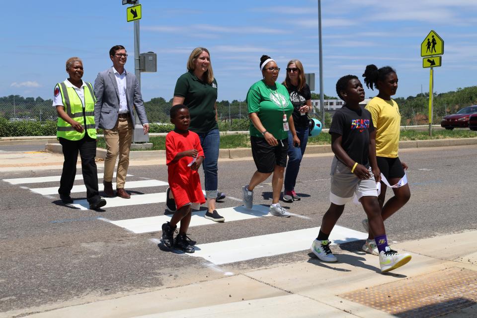 Bike Walk Knoxville and Knoxville’s Community Development Corporation hosted a “first crossing” May 19 for a new signalized crosswalk linking Green Magnet Academy and the First Creek at Austin housing development. Participants included, from left: crossing guard Karen Moon; Ben Bentley, KCDC; Green Magnet Academy student Jonathan Everhart; Lindsey Kimble, Bike Walk Knoxville; Jessica Holman, Green Magnet Academy; Ellen Zavisca, Knoxville Regional Transportation Planning Organization; and Green Magnet Academy students Jeremiah Mingo and Denaysha Echols. May 19, 2023