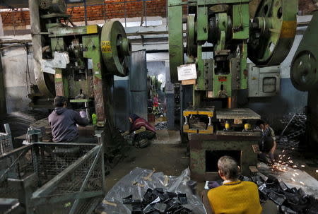 Workers make auto parts on machines inside a manufacturing unit in Faridabad, December 24, 2015. REUTERS/Adnan Abidi/Files