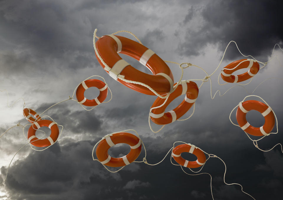 Life Rings flying out beneath storm clouds are a metaphor for rescue, help and aid.