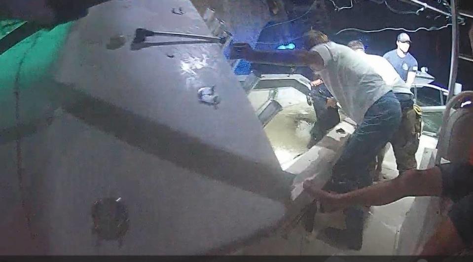 TowBoat US boat captain Kevin Freestone steadies his boat against a sinking Sea Hunter center console after it struck a Florida Keys bridge Monday, July 8, 2024.