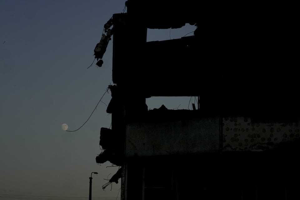 The moon is seen near a building destroyed by attacks in Borodyanka, on the outskirts of Kyiv, Ukraine, Sunday, June 12, 2022. (AP Photo/Natacha Pisarenko)