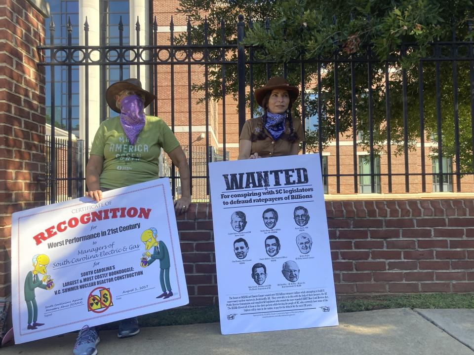 FILE - Protesters against South Carolina’s V.C. Summer nuclear plant stand outside a federal courthouse on July 23, 2020, in Columbia, S.C., after an executive of SCANA Corp. pleaded guilty. Two former executives of the company and one from Westinghouse Electric Co. have pleaded guilty to charges claiming they concealed delays and cost overruns before the reactors were canceled. (AP Photo/Michelle Liu, File)