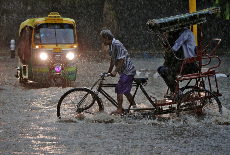 A man pedals his cycle rickshaw during monsoon