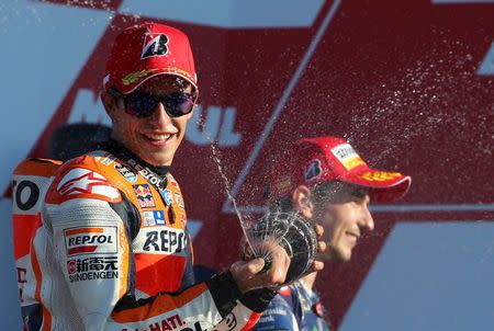 Spanish new World Champion Yamaha MotoGP rider Jorge Lorenzo (R) smiles as Honda rider Marc Marquez of Spain sprays champagne, after Lorenzo won the Valencia Motorcycle Grand Prix at the Ricardo Tormo racetrack in Cheste, near Valencia, November 8, 2015. REUTERS/Heino Kalis