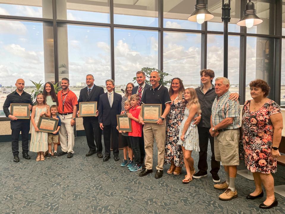 Air traffic controllers and their families receive commendation from Palm Beach County leaders on May 23, 2022. From left: Joshua Somers; Greg Battani and his wife, Molly, their daughter Natalie, 8, and their son, Eli, 6; Mark Saviglia; Palm Beach County Commissioner Gregg Weiss; Ryan Warren and his wife, Karen, their sons Colton, 8, and Tyler, 10; Robert Morgan and his wife Michelle, their daughter Chloe, 11, their son Christian, 16, and Michelle's parents, Norman Letendre and Lorraine Letendre.