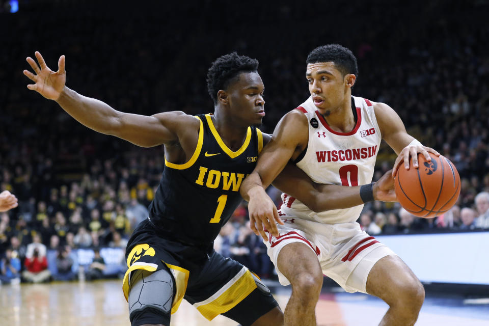 Wisconsin guard D'Mitrik Trice drives past Iowa guard Joe Toussaint, left, during the first half of an NCAA college basketball game, Monday, Jan. 27, 2020, in Iowa City, Iowa. (AP Photo/Charlie Neibergall)