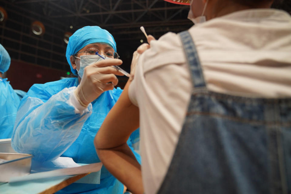 KUNMING, CHINA - APRIL 15: A woman receives COVID-19 vaccine at a temporary vaccination site on April 15, 2021 in Kunming, Yunnan Province of China. The temporary vaccination sites is newly set at a gymnasium in Wuhua District of Kunming, with daily inoculation capacity of about 10,000. (Photo by Liu Ranyang/China News Service via Getty Images)